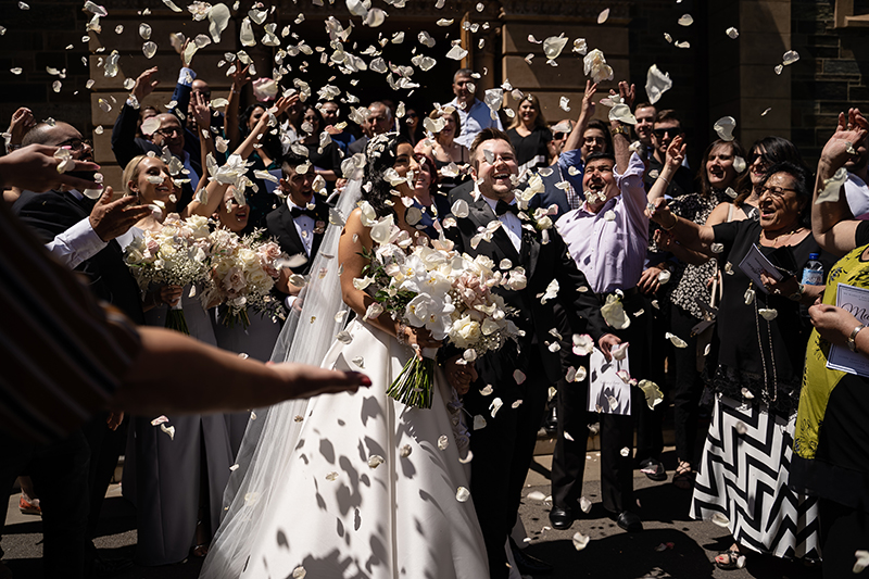 Couple walking out of the Sacrad Heart Church Adelaide with guests throwing confetti, Happy couple just married wedding photography