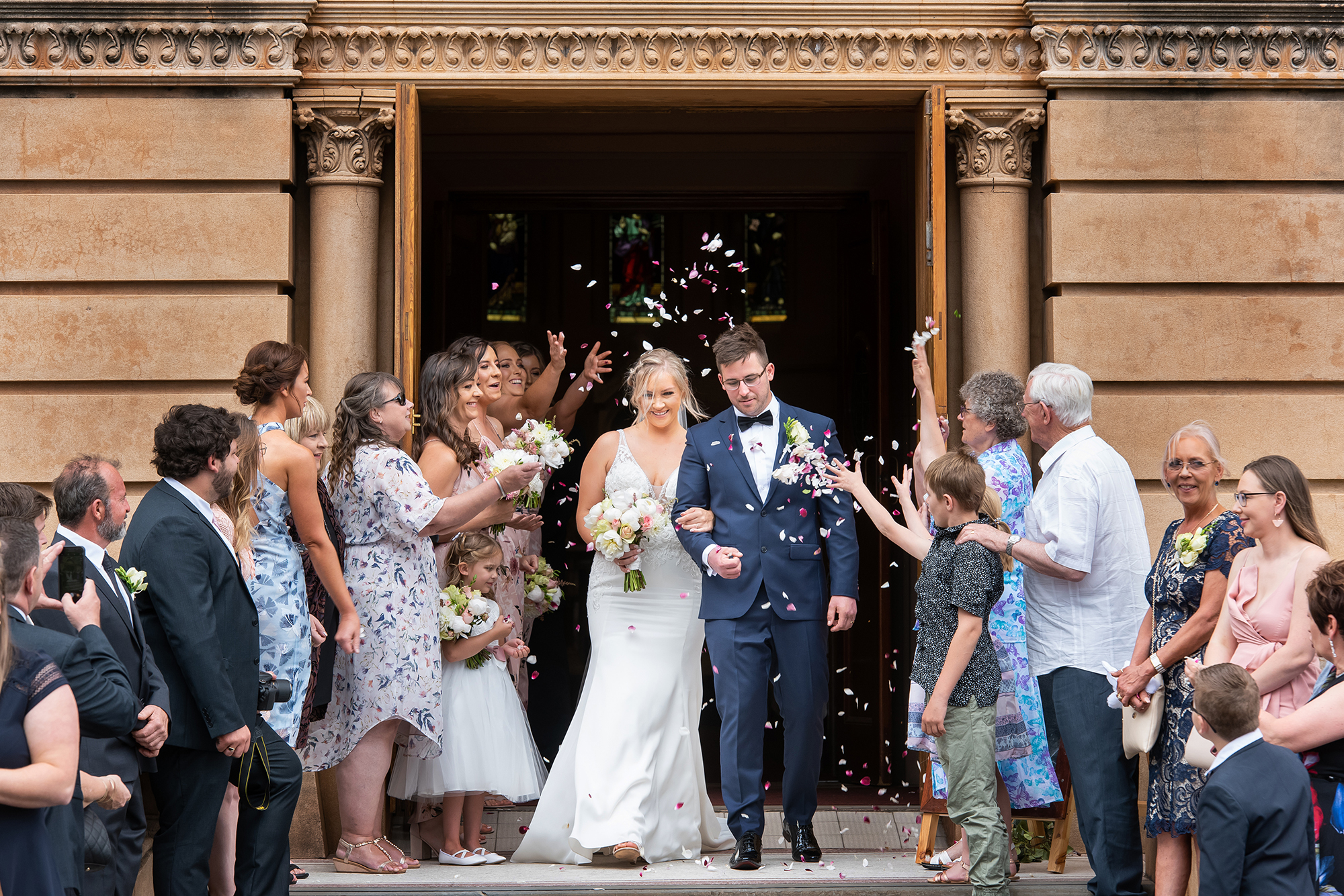 Couple walking out of the church with guests throwing confetti, Adelaide church wedding