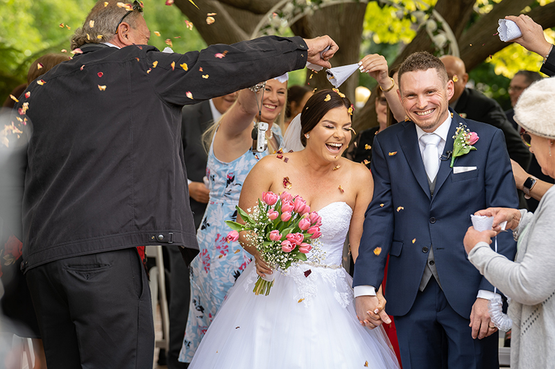 Couple walking down the aisle at Partridge house  garden Glenelg with guests throwing petal confetti, Happy couple just married wedding photography